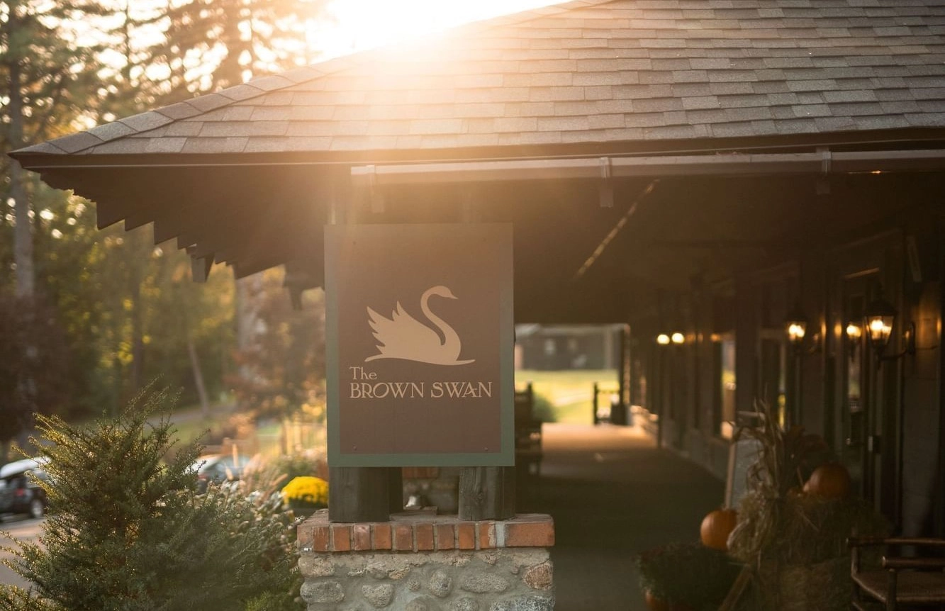 Sign for the Brown Swan on a stone pillar at golden hour.
