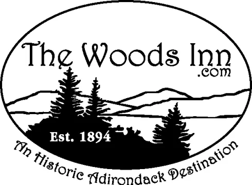 Black and white logo with pine trees, mountain in an oblong badge with The Woods Inn EST 1894 Historic Adirondack Destination