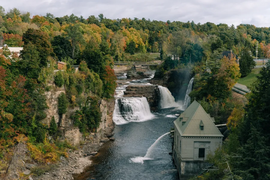 Water crashes over the falls with a building near by