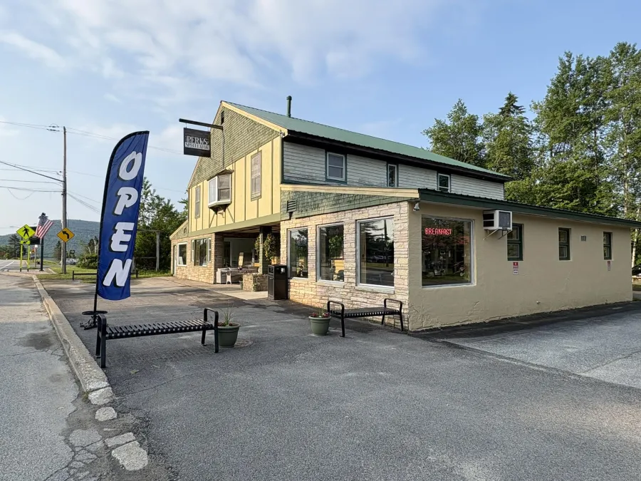 The exterior of PERKS with a blue and white OPEN flag