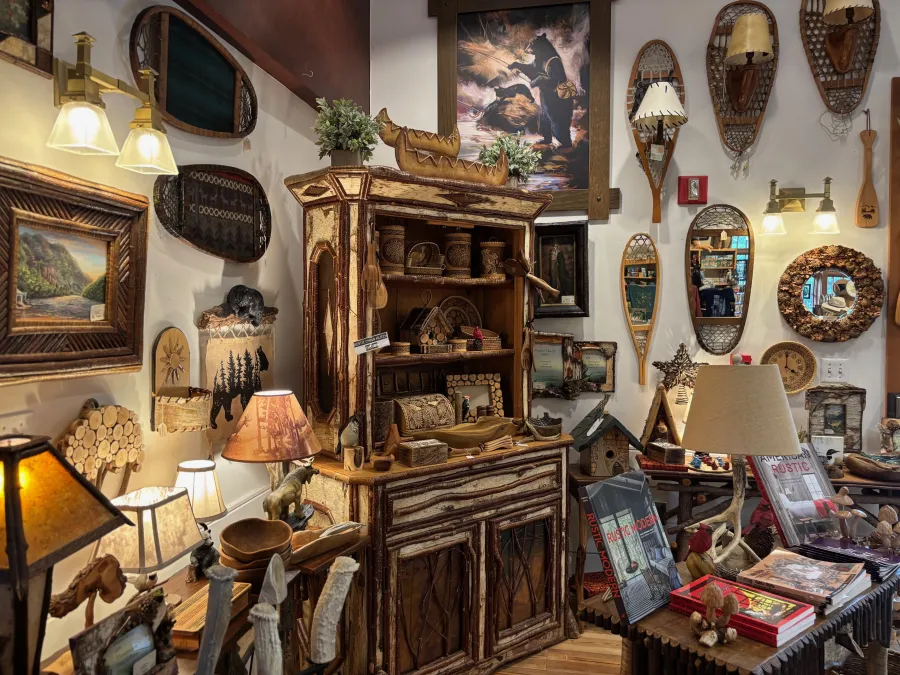 A huge range of rustic decor from bark picture frames to show shoe lamps surrounding a birch bark hutch.